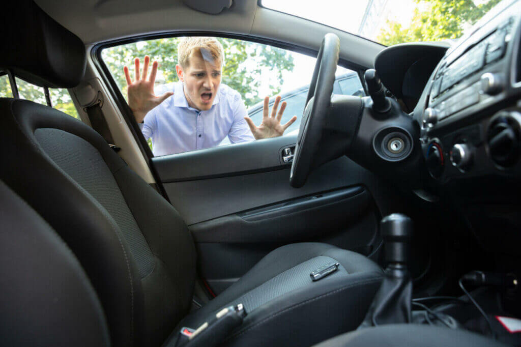 Locksmith to Unlock a Car: How Do Locksmiths Open Car Doors? A distressed person looking through window at the keys locked in car