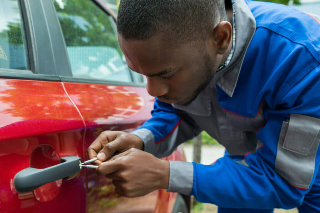 Is a Locksmith or Dealership Best for Car Key Replacement? A locksmith working on a car door lock