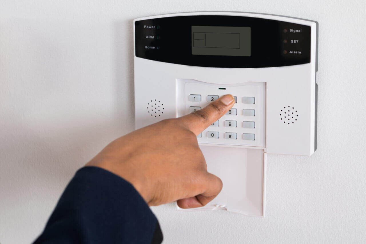 A person inputting the code into a smart door lock keypad