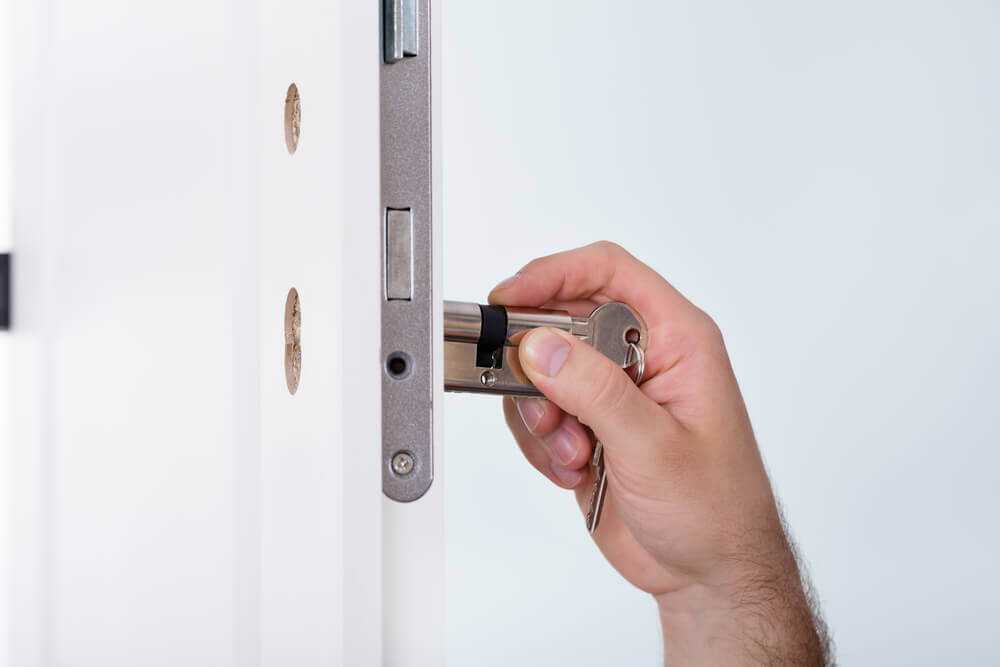 A Hand Installing A Lock