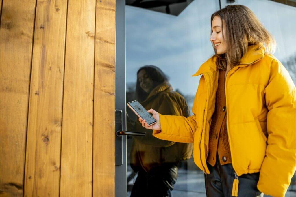 A Person Unlocking The Door With A Smart Lock App 1024x683