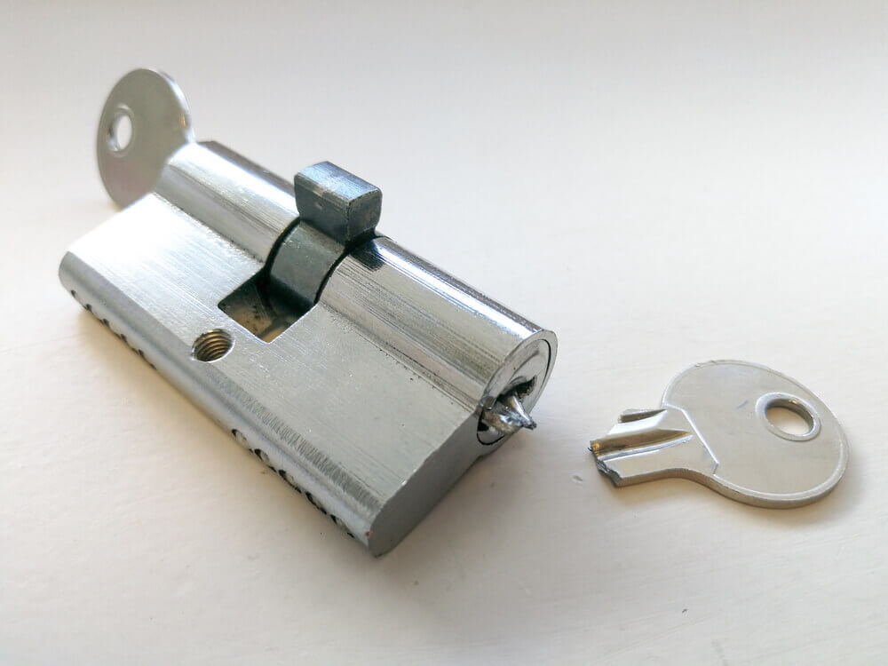 Broken Key With Its Half In The Lock Lying On A Surface