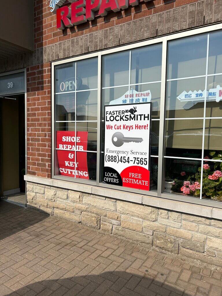 A storefront offers shoe repair and key cutting services. A sign on the window advertises "Faster Locksmith," providing emergency services and key cutting. The sign includes a phone number, locksmith promotions, local offers, and a notice for free estimates.